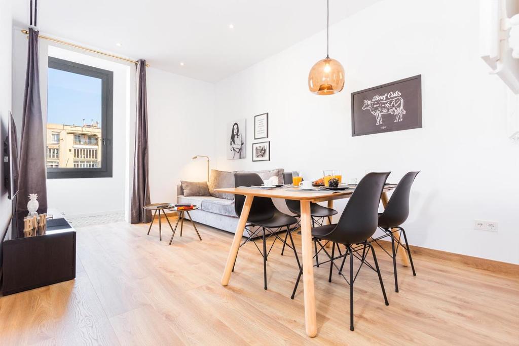 a dining room and living room with a table and chairs at Cozy Apartment close to Passeig de Gracia in Barcelona