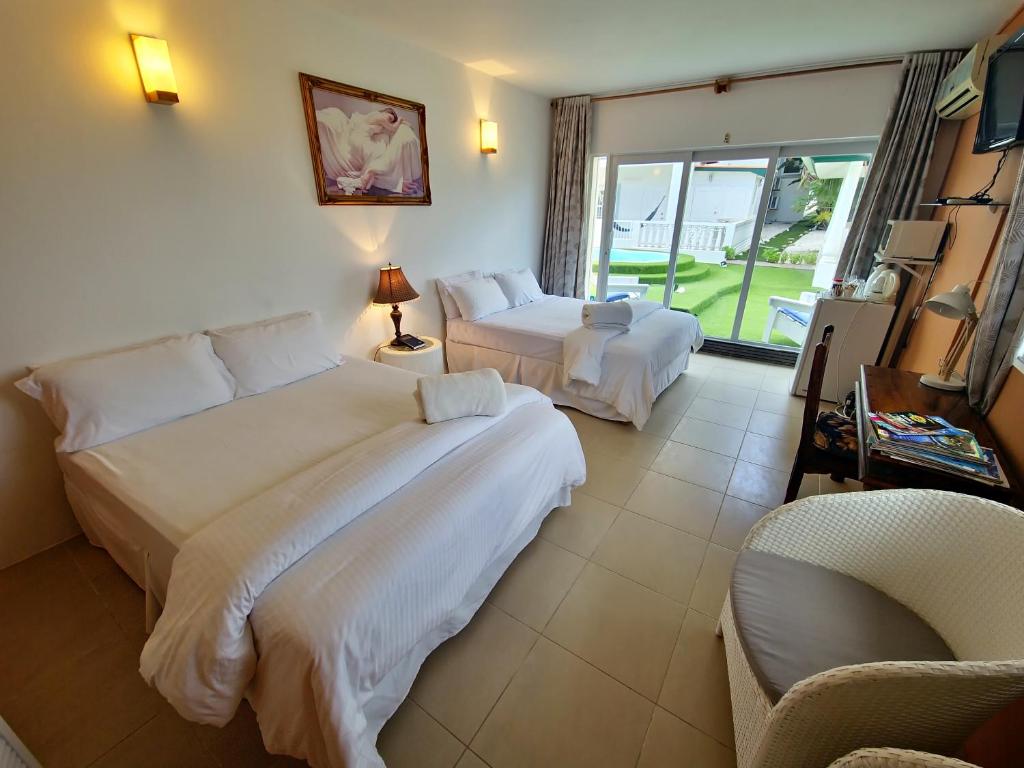 una habitación de hotel con 2 camas y una silla en Adonai Hotel Boutique en Willemstad