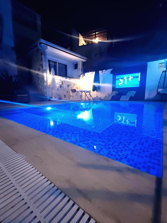 a swimming pool at night with a sign in the water at EXEN BY WEEKEND in Bodrum City