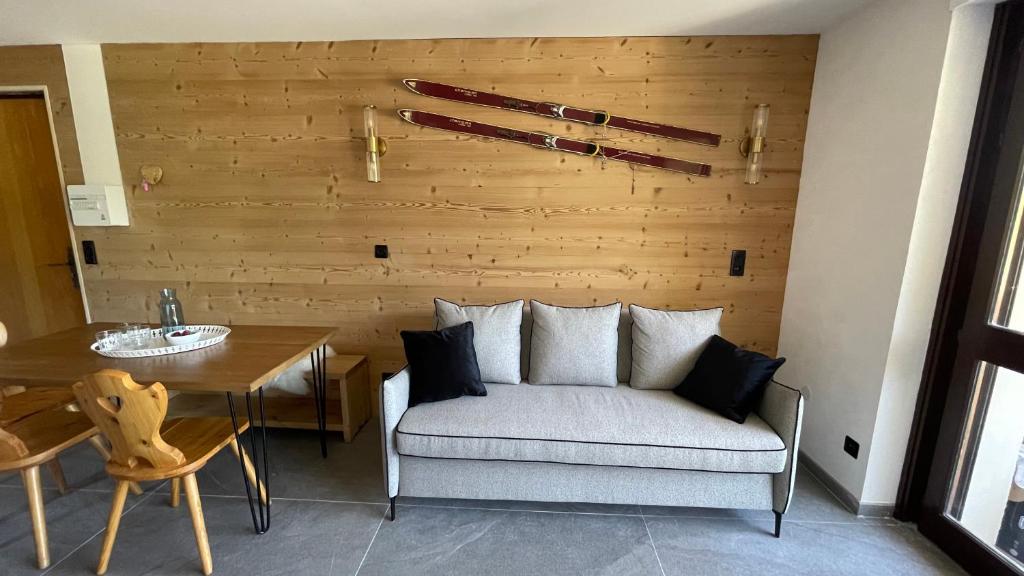 una camera con divano, tavolo e parete in legno di Morzine : bel appartement à 5 mn du téléphérique a Morzine
