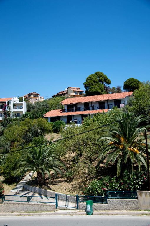 a building on top of a hill with palm trees at Villa Anna in Megali Ammos