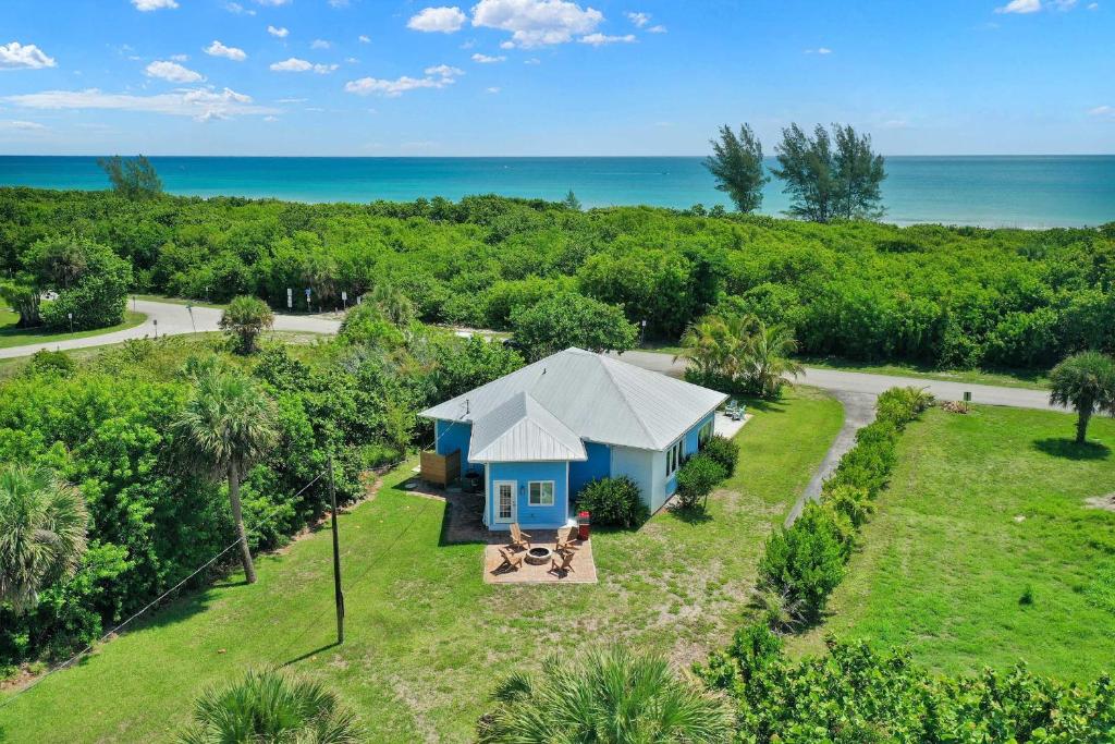 an aerial view of a cottage with the ocean in the background at Hutchinson Island Cottage Steps to the Beach in Fort Pierce