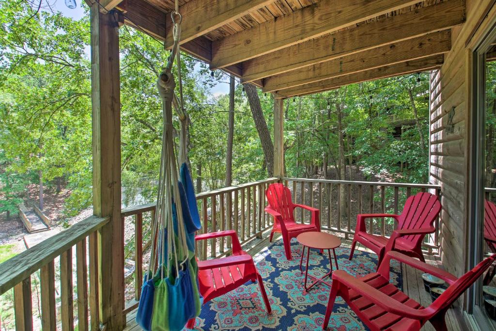 une véranda avec des chaises rouges et une table dans l'établissement Mount Ida Condo with Balcony and Resort Amenities, à Mount Ida