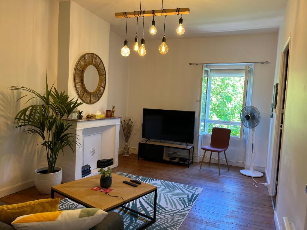 uma sala de estar com um sofá e uma televisão em Très bel appartement tout proche du centre ville em Montélimar