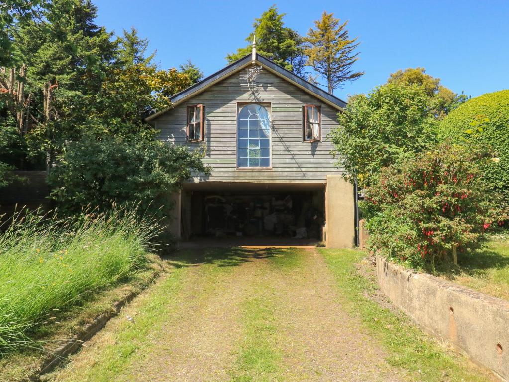 an old house with a garage in a yard at Detox Dunchideock in Exeter