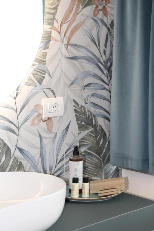 a bathroom with a sink and a shower curtain at C House Rooms Lake in Peschiera del Garda