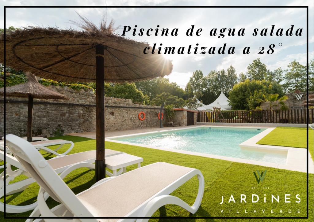 a swimming pool with two chairs and an umbrella at Jardines Villaverde in Villaverde de Pontones