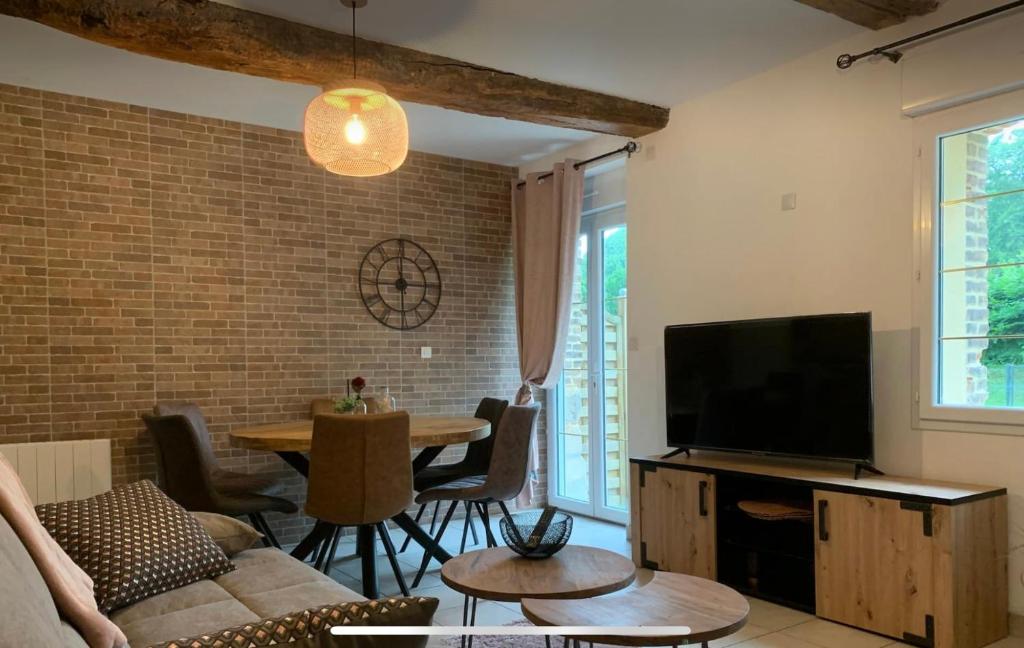 ein Wohnzimmer mit einem Sofa, einem TV und einem Tisch in der Unterkunft D2 CHARMANT duplex proche de la mer, avec jardin in Ingouville