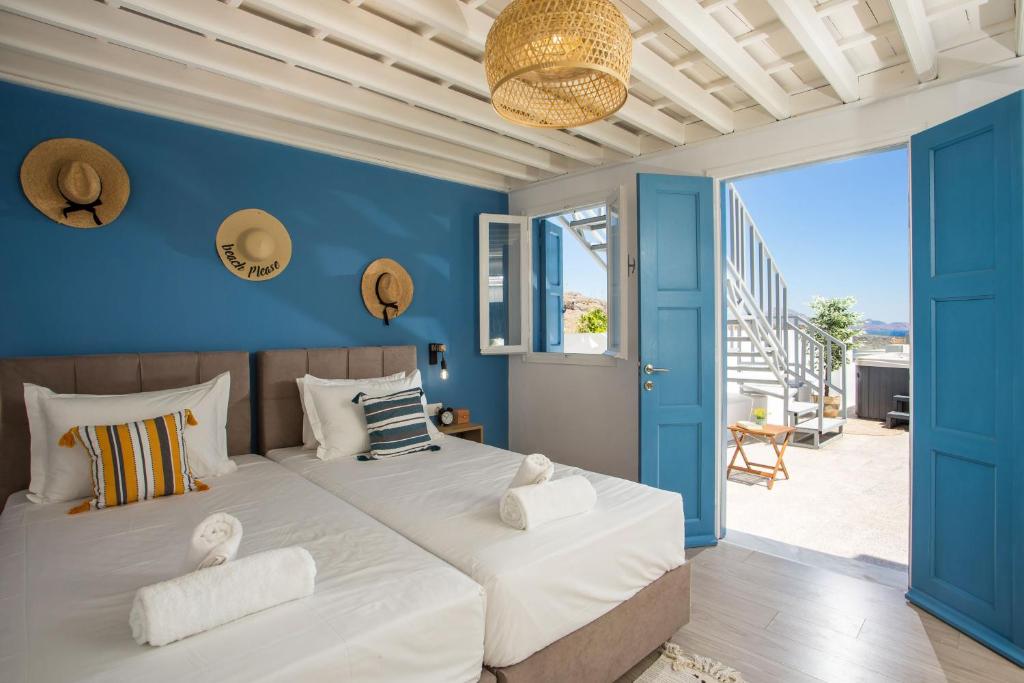 a bedroom with a large bed with blue walls at Villa Euphrosyne in Líndos