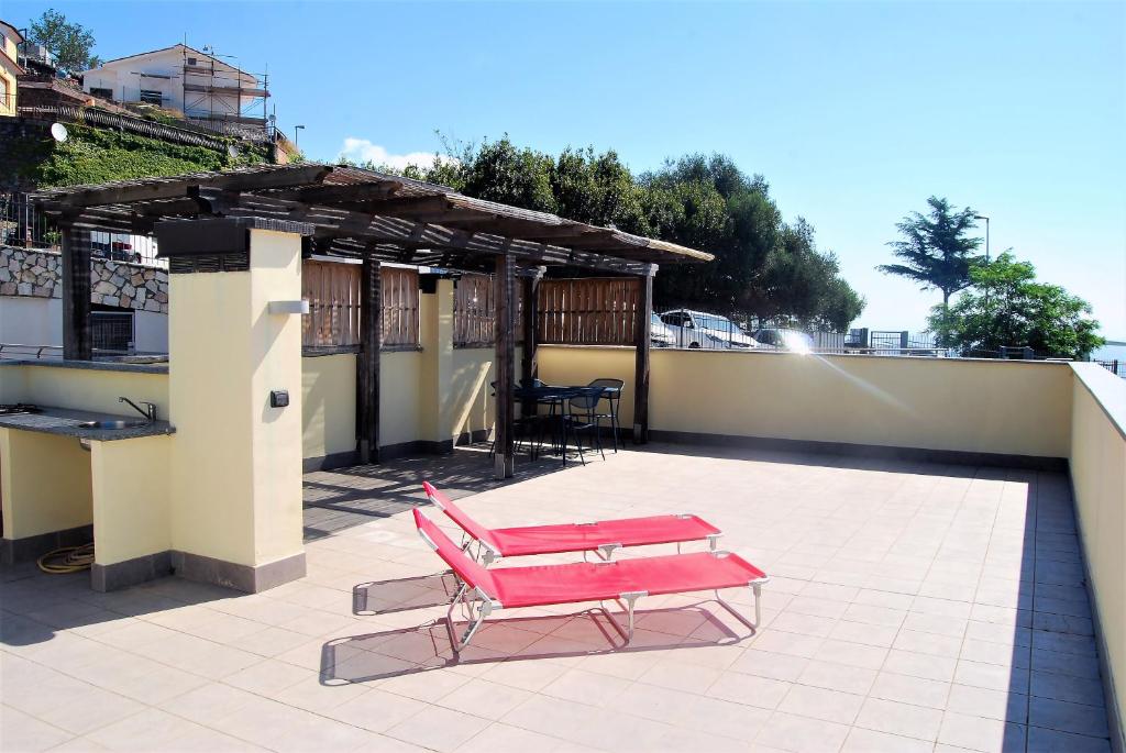 un banc rose assis au-dessus d'un toit dans l'établissement Yellow House, à Albissola Marina