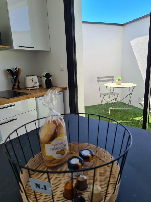 a basket with bread and bottles on a table in a kitchen at Location LA BELLE - LA ROCHELLE B in La Rochelle