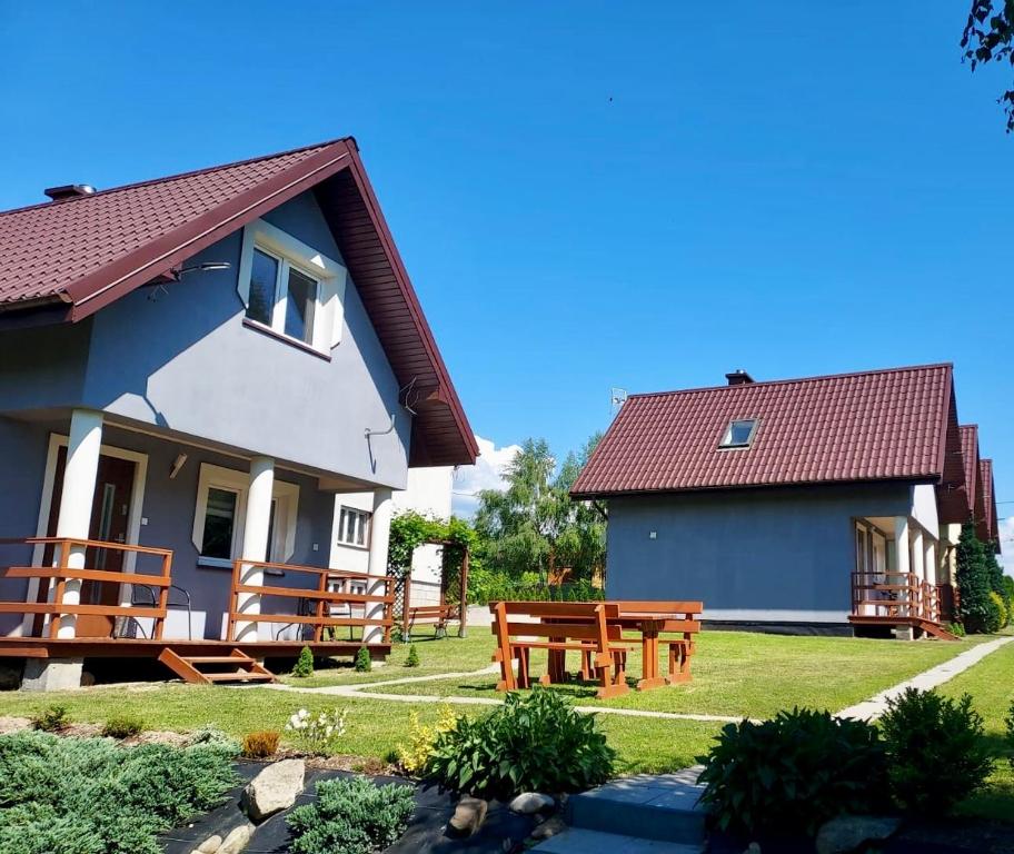 une maison avec bancs dans la cour dans l'établissement Domki u Marka, à Polańczyk