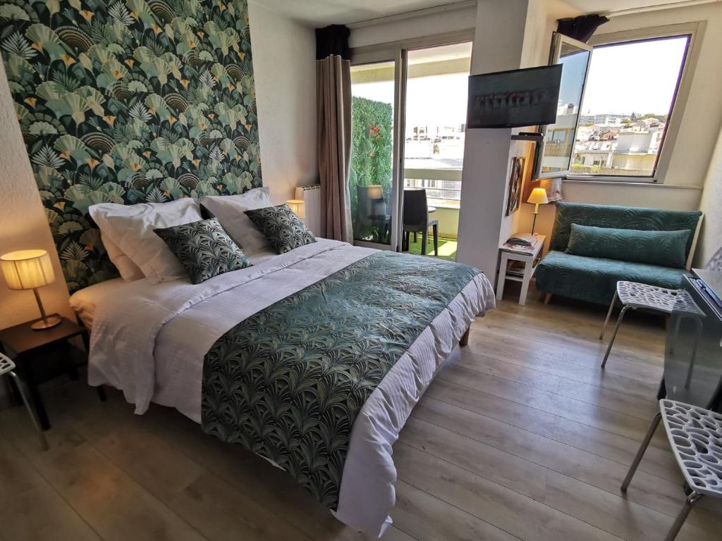 - une chambre avec un lit et une chaise verte dans l'établissement Ocean 7, à Biarritz