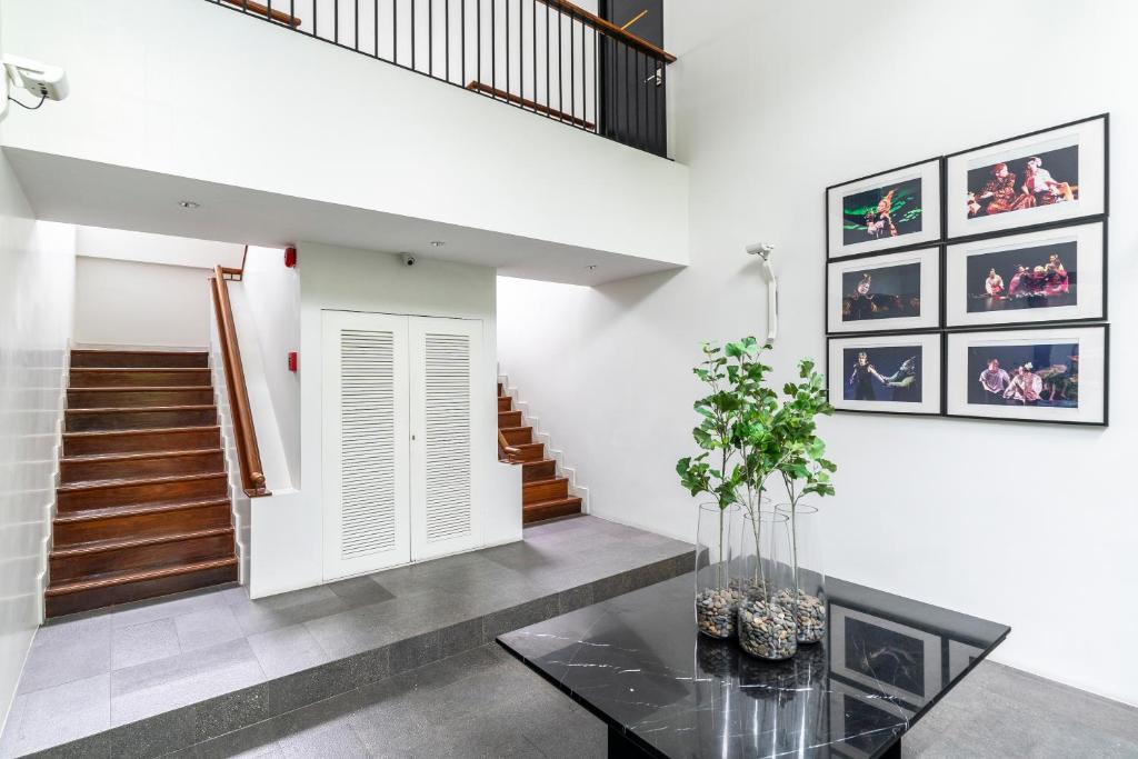 A bright, gallery-like internal landing with stairs and theatre artwork.