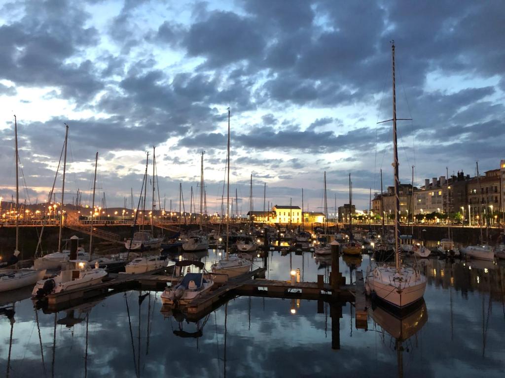 un groupe de bateaux amarrés dans un port de plaisance la nuit dans l'établissement Alojamientos Muelle de Gijón, à Gijón