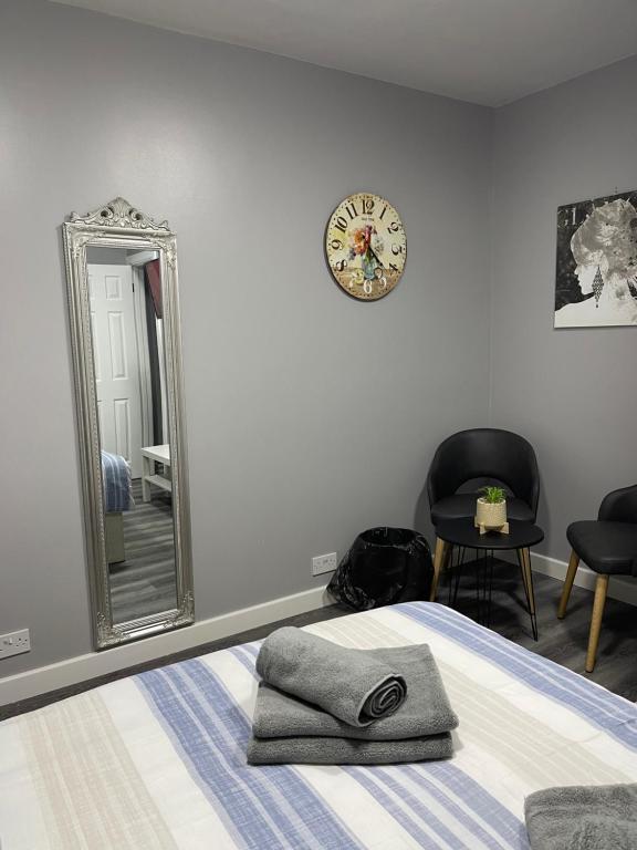 sypialnia z łóżkiem, lustrem i krzesłem w obiekcie Grays Accommodation B&B w mieście Grays