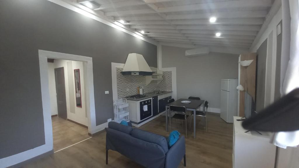 a living room with a blue couch and a kitchen at Iacovino Country House in Sarzana