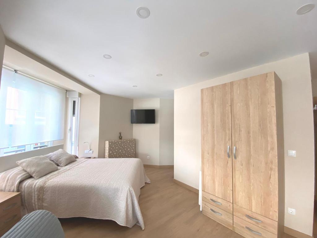 A bed or beds in a room at Alojamientos Muelle de Gijón