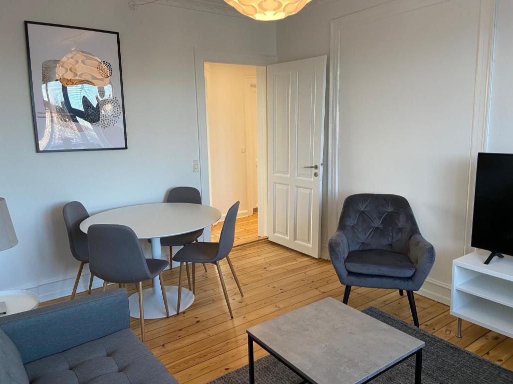 - un salon avec un canapé, une table et des chaises dans l'établissement Lovely and homey Apartment at Frederiksberg, à Copenhague