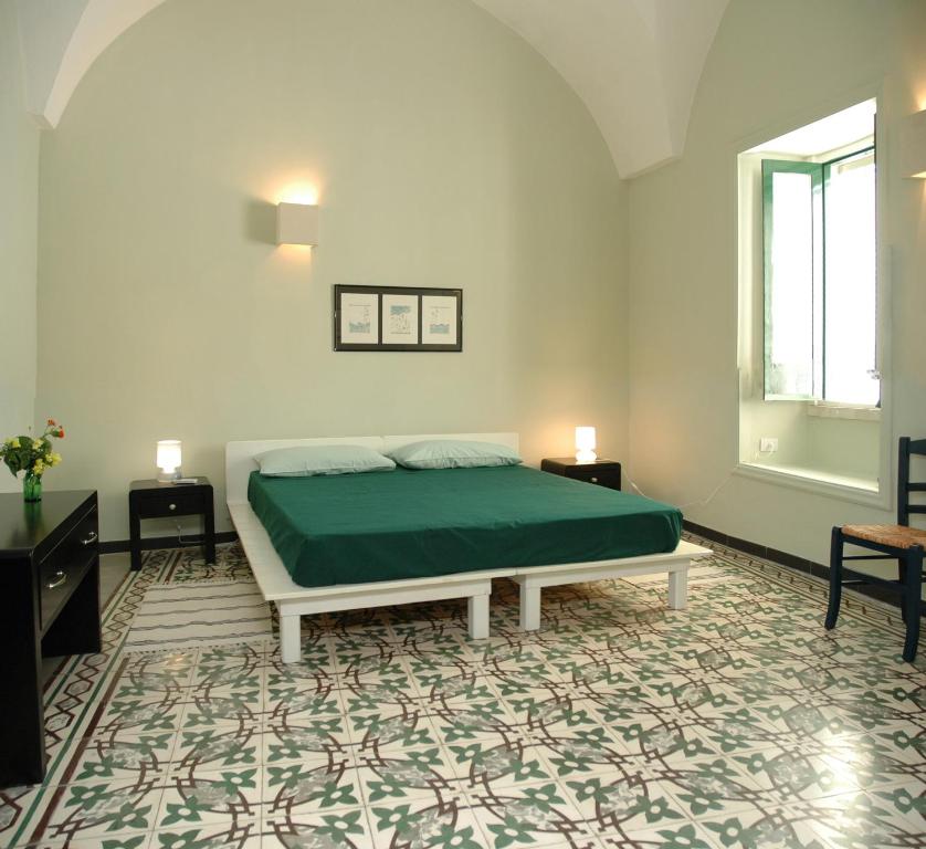 a bedroom with a bed and two tables and a window at B&B di Pino Conte in Serrano