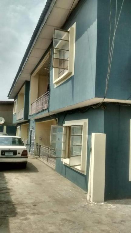 a blue building with two windows and a refrigerator at Impeccable 3-Bed Apartment Located in Lagos in Lagos