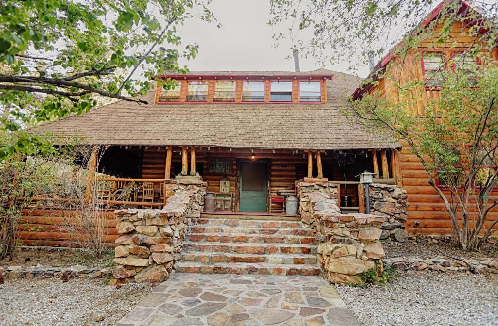 una casa de madera con una escalera que conduce a la puerta principal en Gold Mountain Manor en Big Bear City