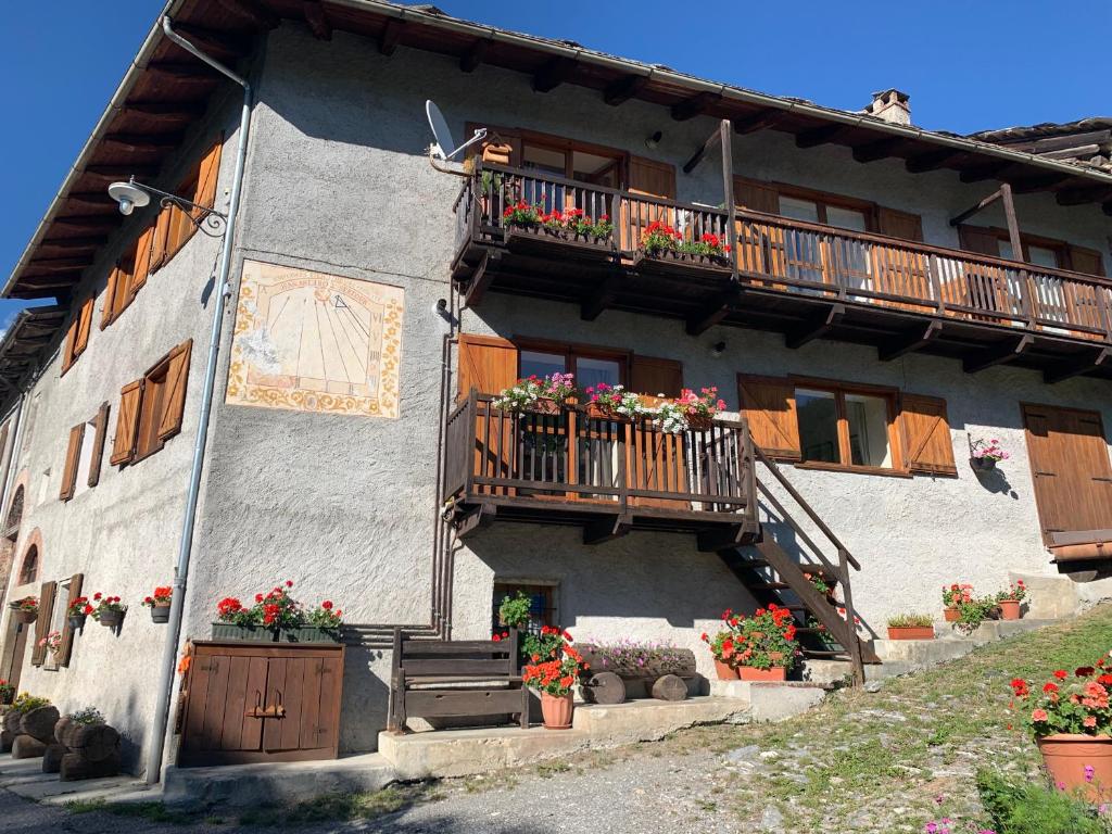 a building with flower pots and balconies on it at San Marco FARMHOUSE with a view. in Sauze dʼOulx