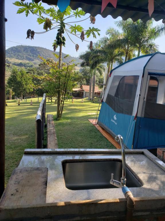 ein blauer LKW in einem Park mit einem Waschbecken geparkt in der Unterkunft Locação De Barracas EcoPark in São Pedro