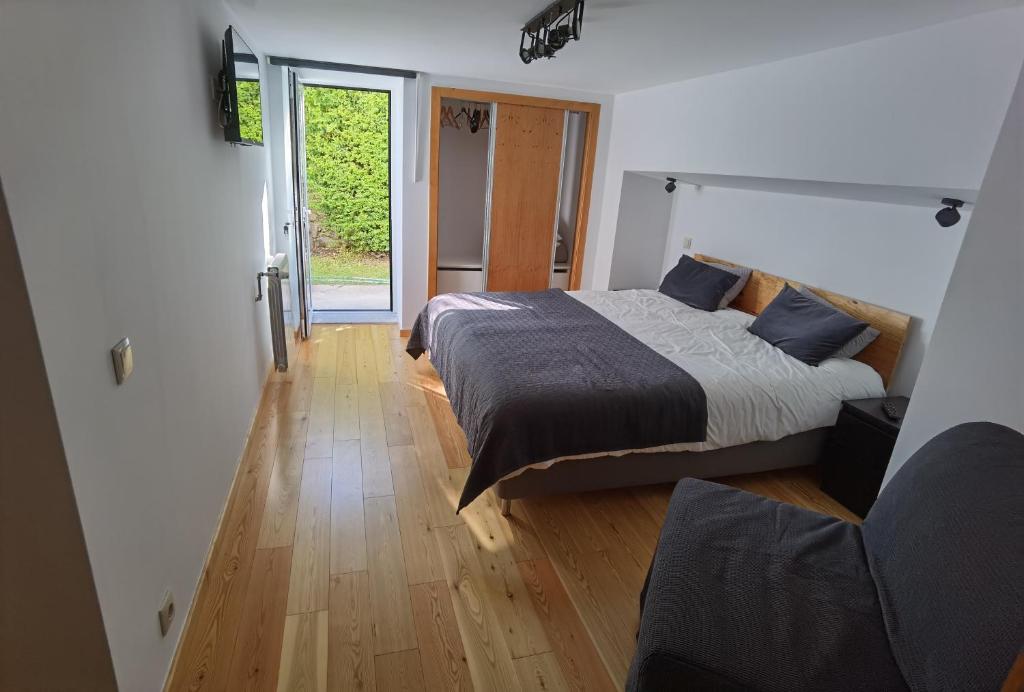 a bedroom with a bed and a wooden floor at Fernandes House in Paredes de Coura