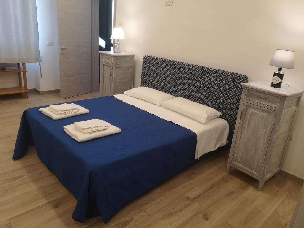 Una cama azul con dos toallas encima. en Delcicer casa vacanze o camera privata, en Galatina