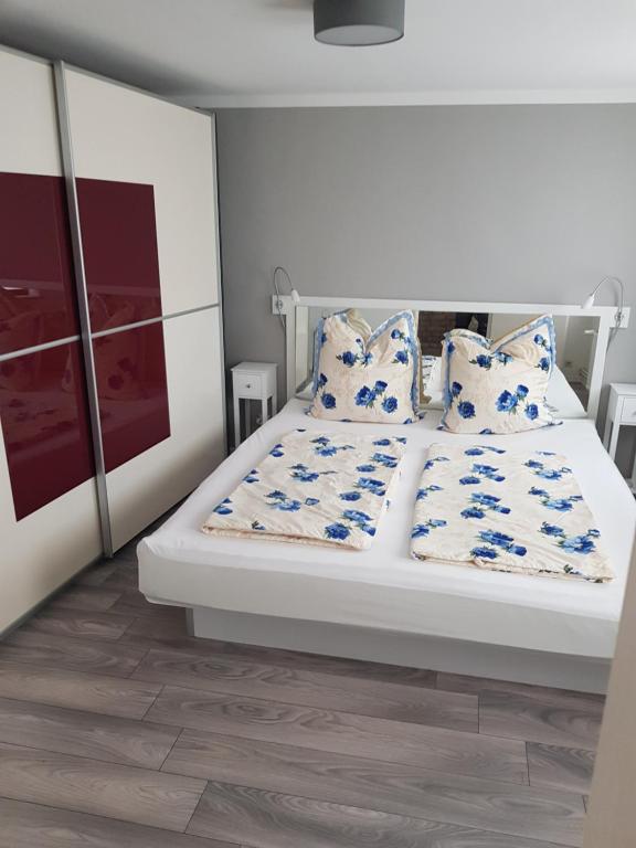 um quarto com uma cama branca com almofadas azuis e brancas em Inselblüte 2 em Werder