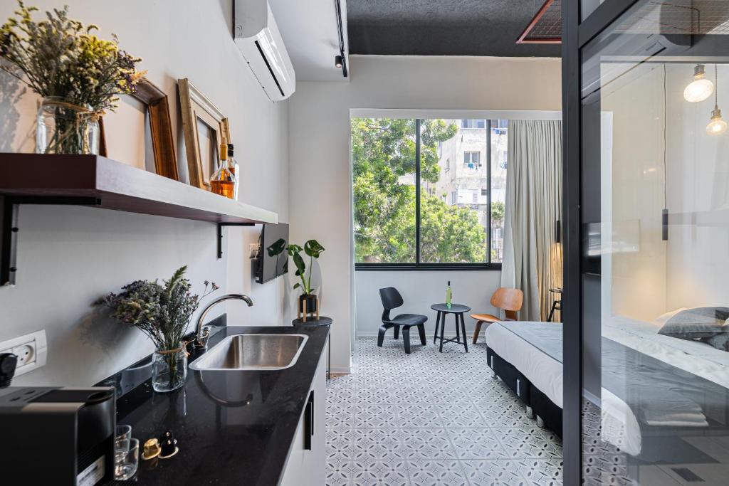 1 dormitorio con 1 cama y lavamanos en una habitación en Levinski Market Hotel, en Tel Aviv