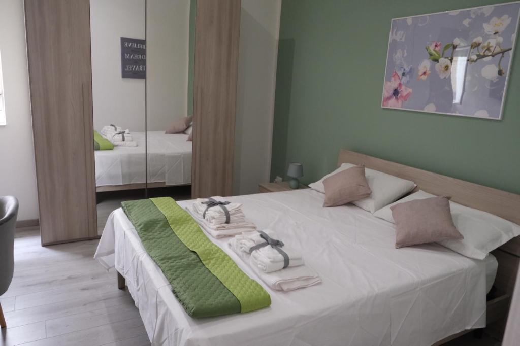Schlafzimmer mit einem großen weißen Bett und einem Spiegel in der Unterkunft Casa Beatrice Affittacamere - Dante in Palermo
