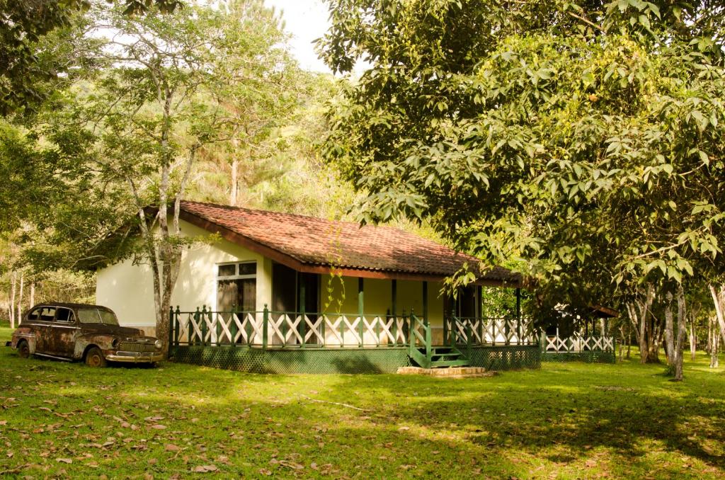 une petite maison avec une voiture garée devant elle dans l'établissement Parque Natural Ixpanpajul, à Santa Elena