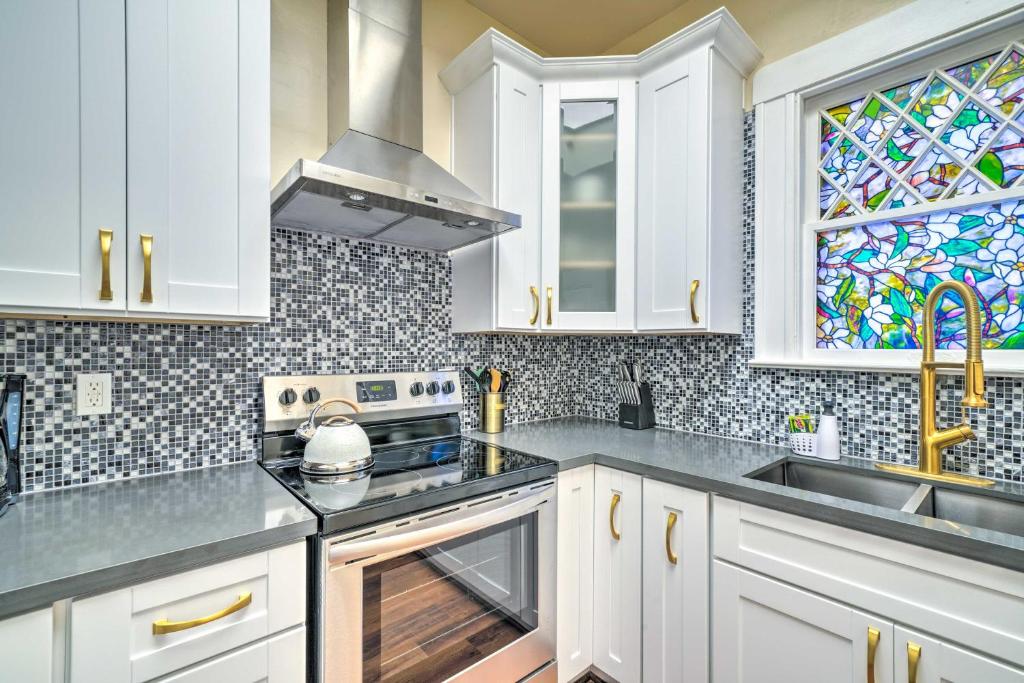 a kitchen with white cabinets and a stained glass window at Cozy Carpinteria Apartment Walkable Location in Carpinteria