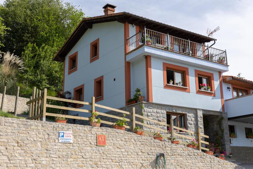 a white house with a balcony on top of a wall at La besñada in Cangas de Onís