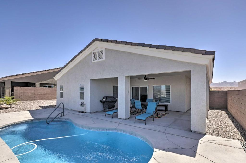 a backyard with a swimming pool and a house at Sunny Bullhead City Home with Patio and Mnt View! in Bullhead City