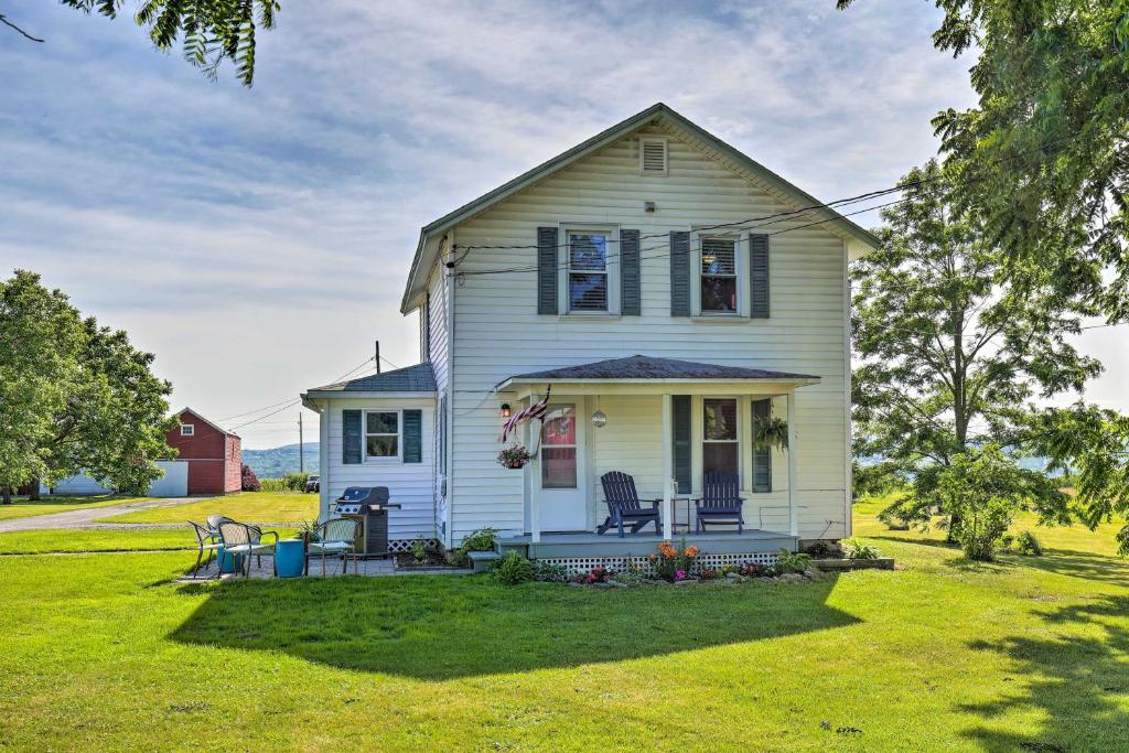 a white house with a porch and a lawn at Finger Lakes Farm Retreat Walk to Wineries! in Hector