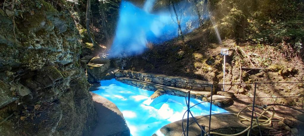 a waterfall in the woods with blue water at Il Rifugio Di Artemide AGRITURISMO in Perinaldo