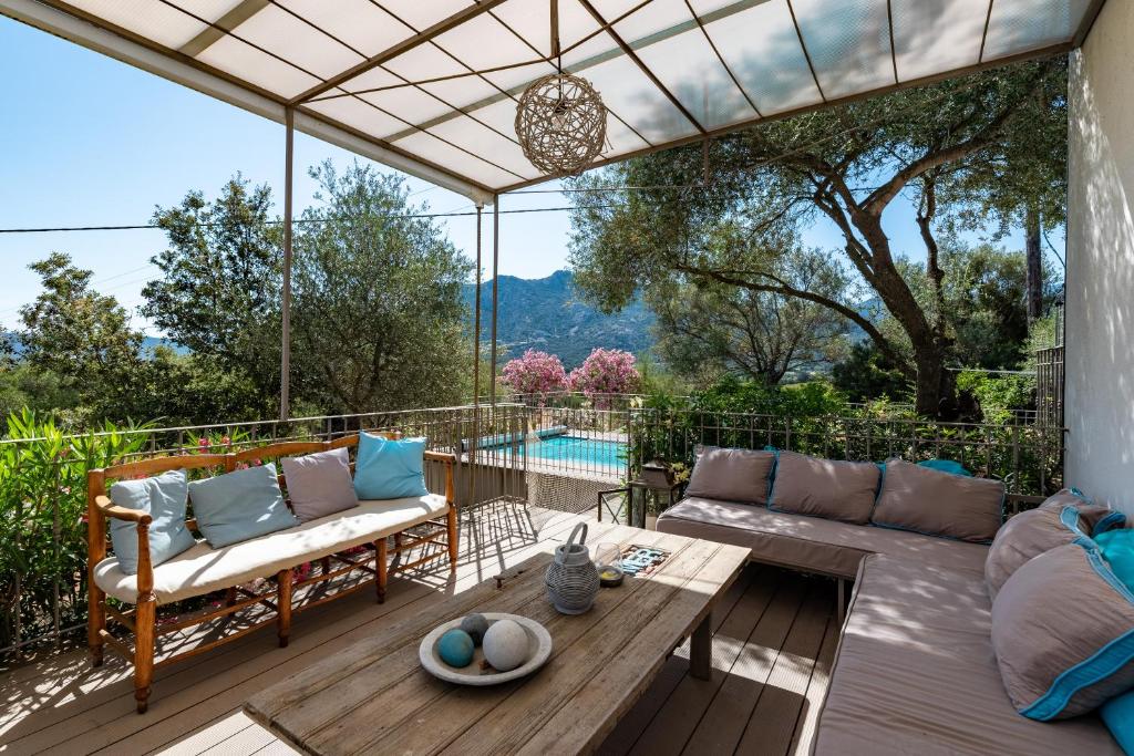 un patio con sofá y mesa en La Maison des Oliviers - Belle maison familiale avec Piscine, en Occhiatana