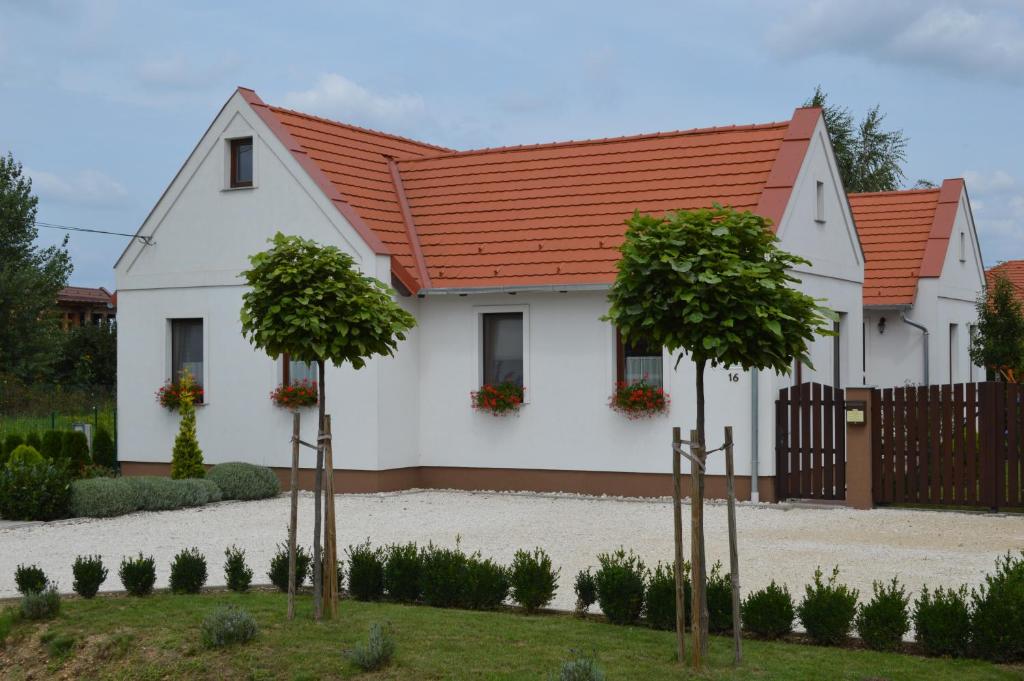 una casa blanca con techo naranja en Levendula Apartman, en Hegykő