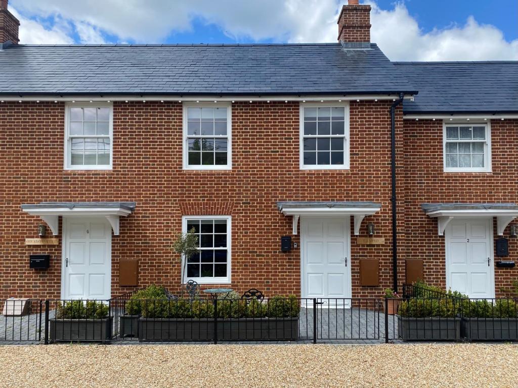 a red brick house with white doors at Lilypad A central location to explore the New Forest & South Coast in Ringwood