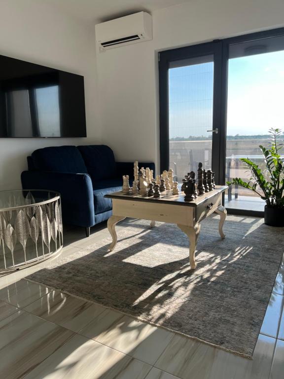 salon ze stołem z szachami w obiekcie Sprezzatura Apartament w mieście Agigea