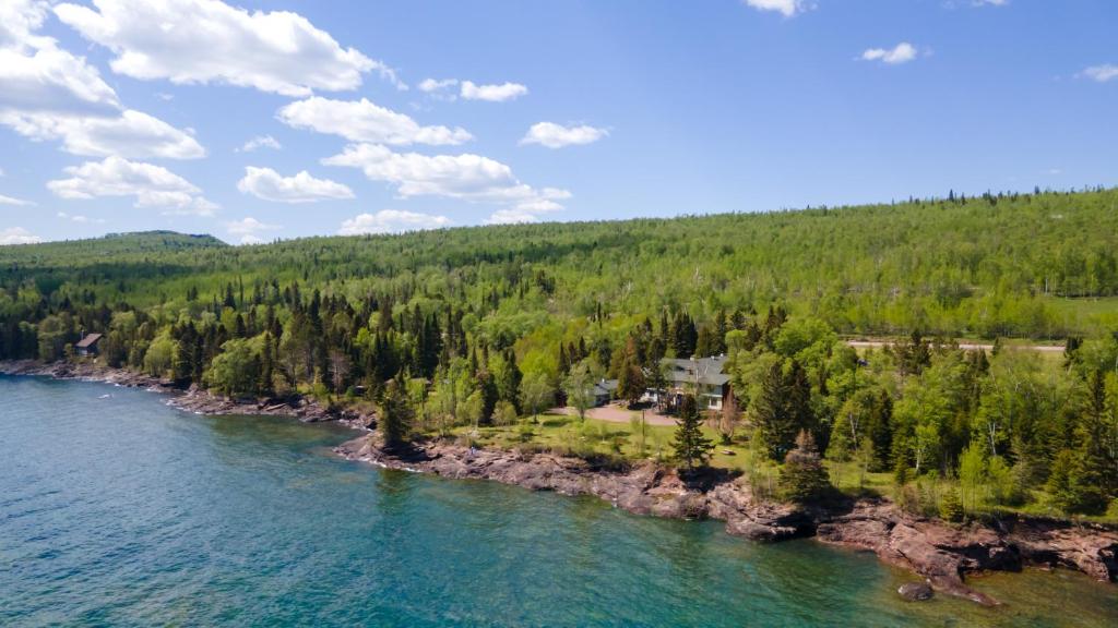 an aerial view of a house on the shore of a river at Thomsonite Inn on Lake Superior in Grand Marais