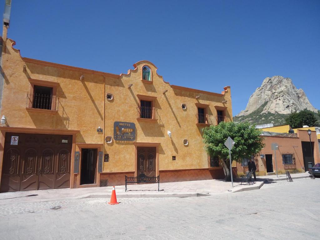 an old building with a mountain in the background at Hotel San Isidro in Bernal