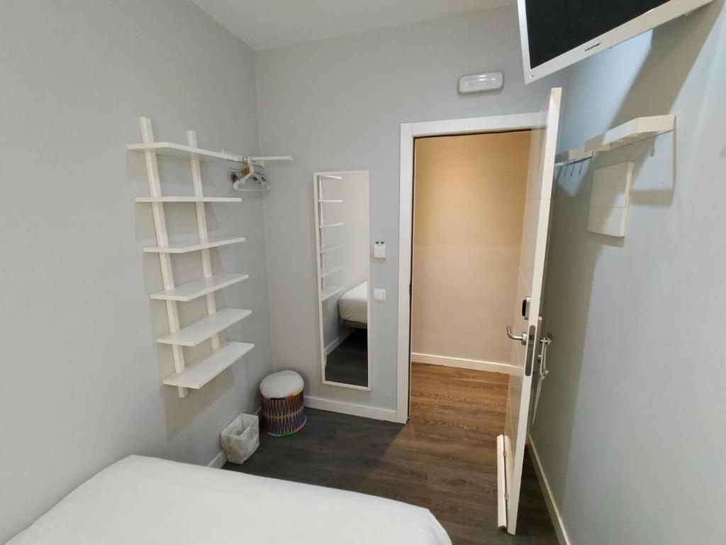 1 dormitorio con 1 cama y puerta al baño en diezmadrid, en Madrid