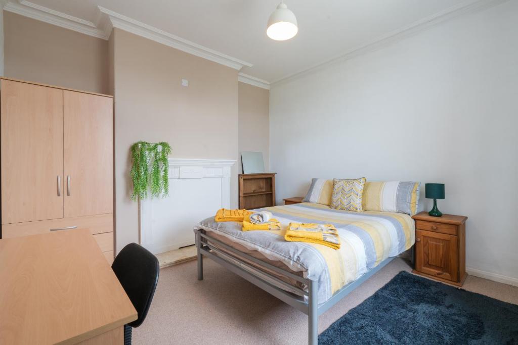a bedroom with a bed and a desk and a table at Spacious 4BR, Parking, Near Centre, Accommodates 7 in Sheffield