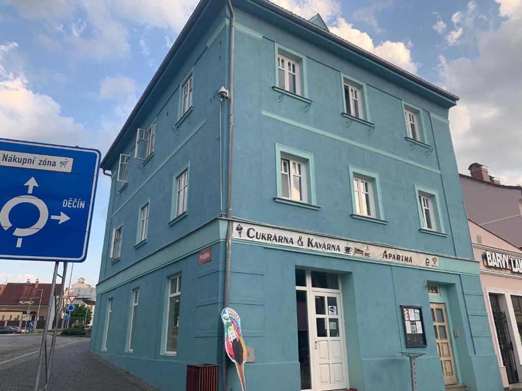een blauw gebouw met een bord ervoor bij Apartmá u Baštů in Česká Kamenice