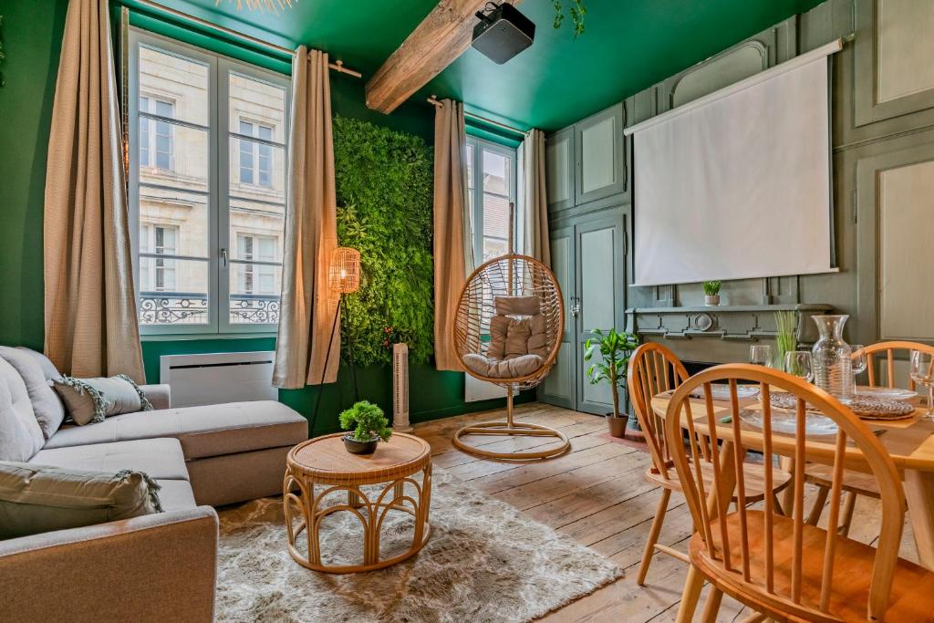 a living room with green walls and a table and chairs at Appartement Jungle - Libourne Centre - 4 pers - Sauna - Netflix in Libourne