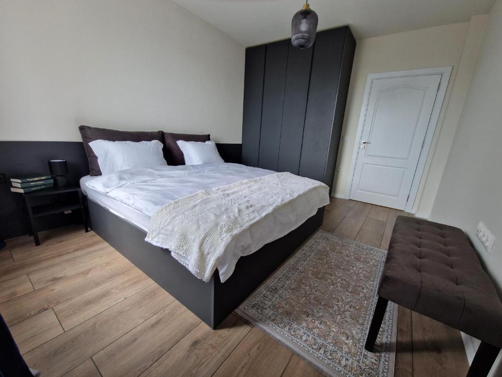 a bedroom with a large bed and a table at Apartment Enya in Burgas